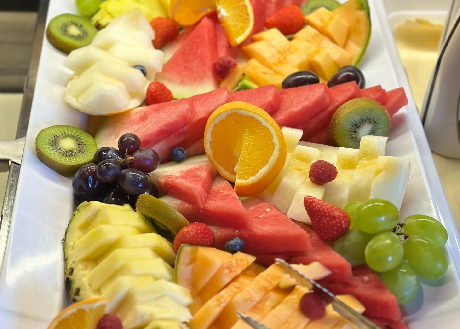 Bunte Obstplatte mit Melone, Kiwi, Trauben und Orangen