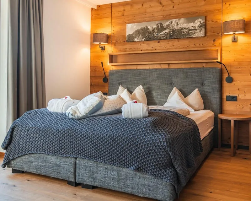 Junior Suite B SUP mit gemütlichem Doppelbett und Holzwand