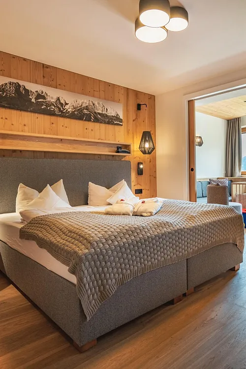 Komfortables Doppelzimmer mit Holzwand und gemütlicher Beleuchtung