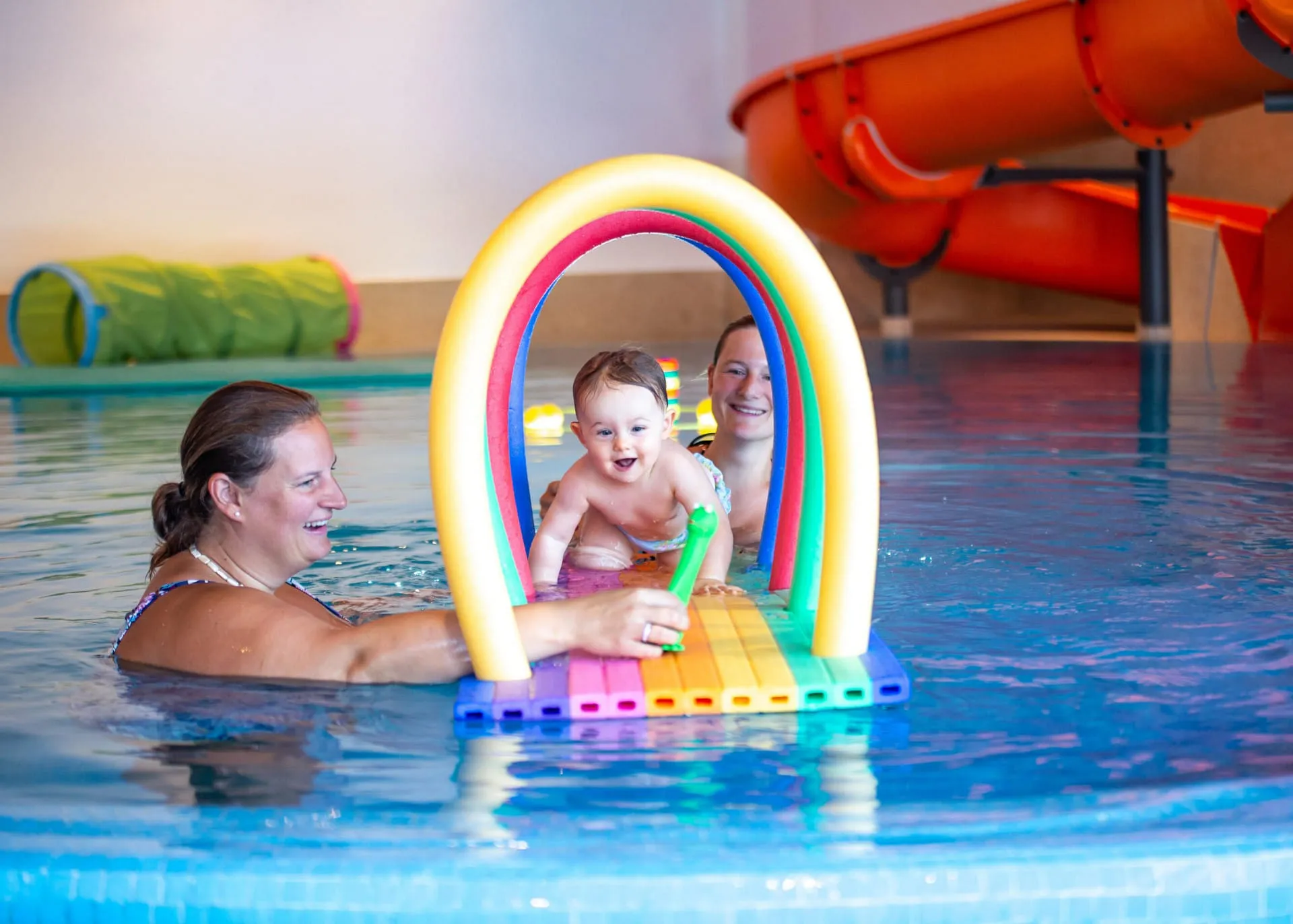 Mütter spielen mit Baby bzw. Kleinkind im Hallenschwimmbad des Hotel