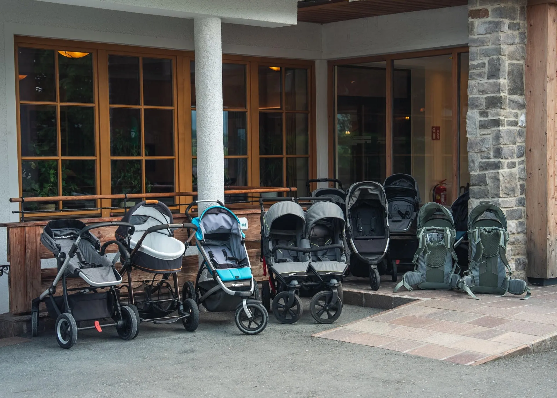 Reihe von Kinderwagen zum Ausleihen vor dem Hotel Babymio in Tirol