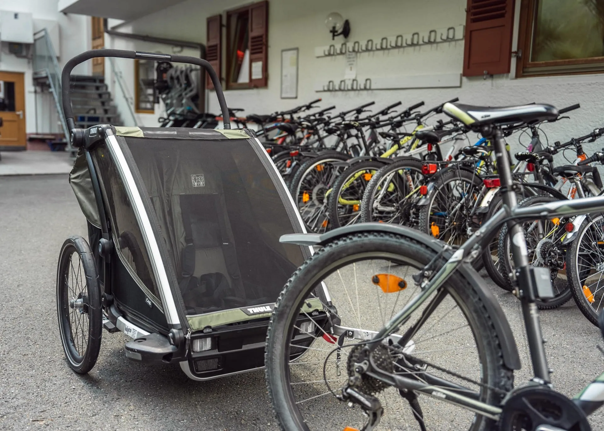 Fahrräder mit Kindersitz oder Anhänger zum Verleih vor dem Hotel